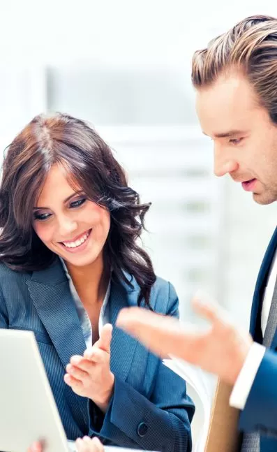 Business professionals discussing data on a laptop, illustrating collaboration and real-time insights for improved productivity with PracticeERP.