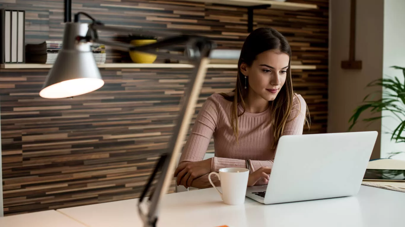 Young professional working on a laptop in a modern office setting, emphasizing technology use for enhancing efficiency in CPA firms.