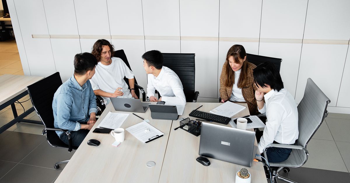 Group of coworkers brainstorming ideas during a collaborative team meeting in a bright office.