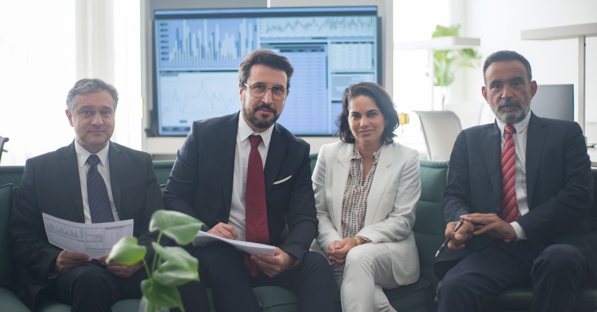 Professional team in corporate attire ready for a meeting, engaged in discussion.