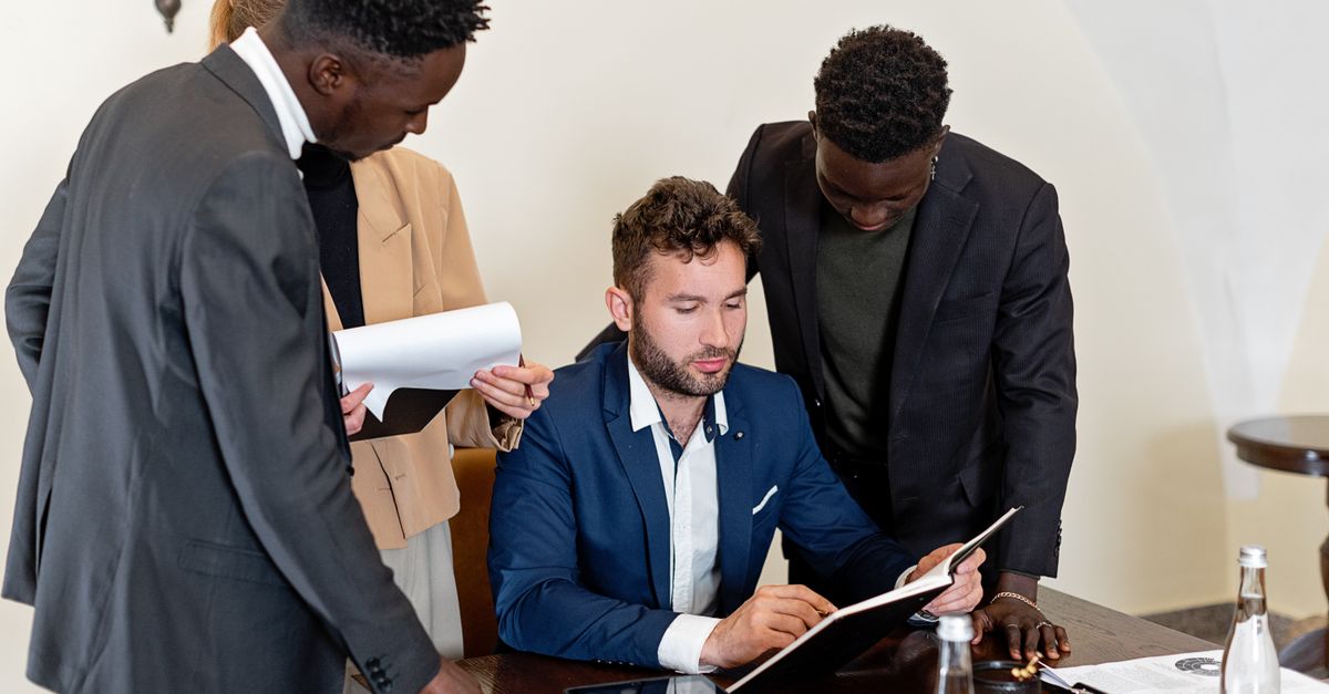 A diverse team collaborating in an office meeting, focusing on documents and teamwork.
