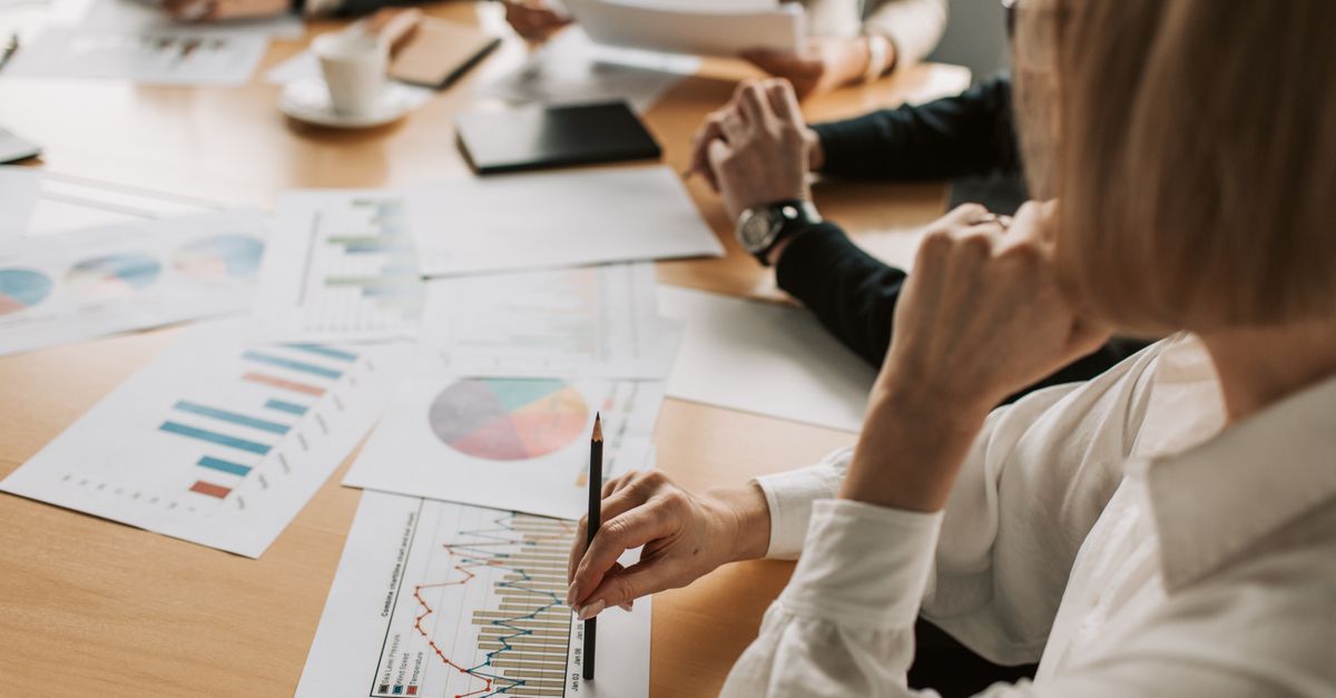 Business professionals reviewing charts and graphs during a meeting in office setting.