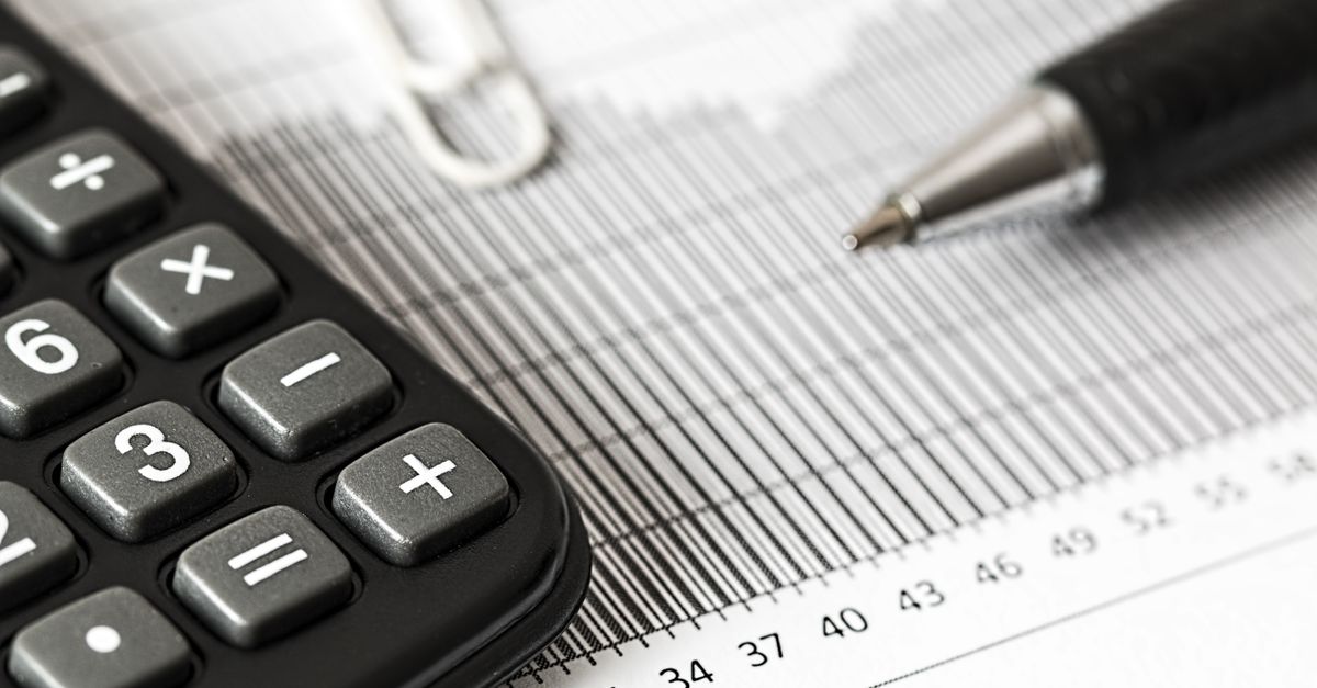 Close-up of a calculator and pen on a bar graph, representing finance and accounting.
