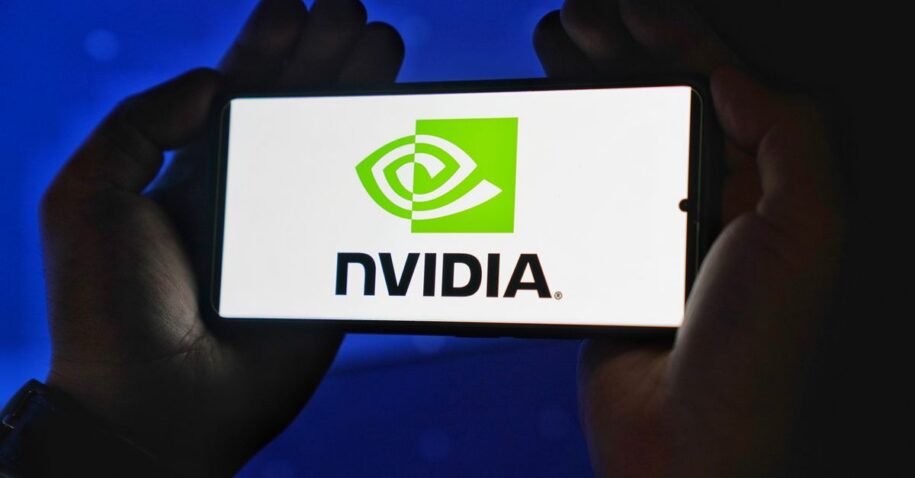 Hands holding a smartphone showing the NVIDIA logo on a bright screen.