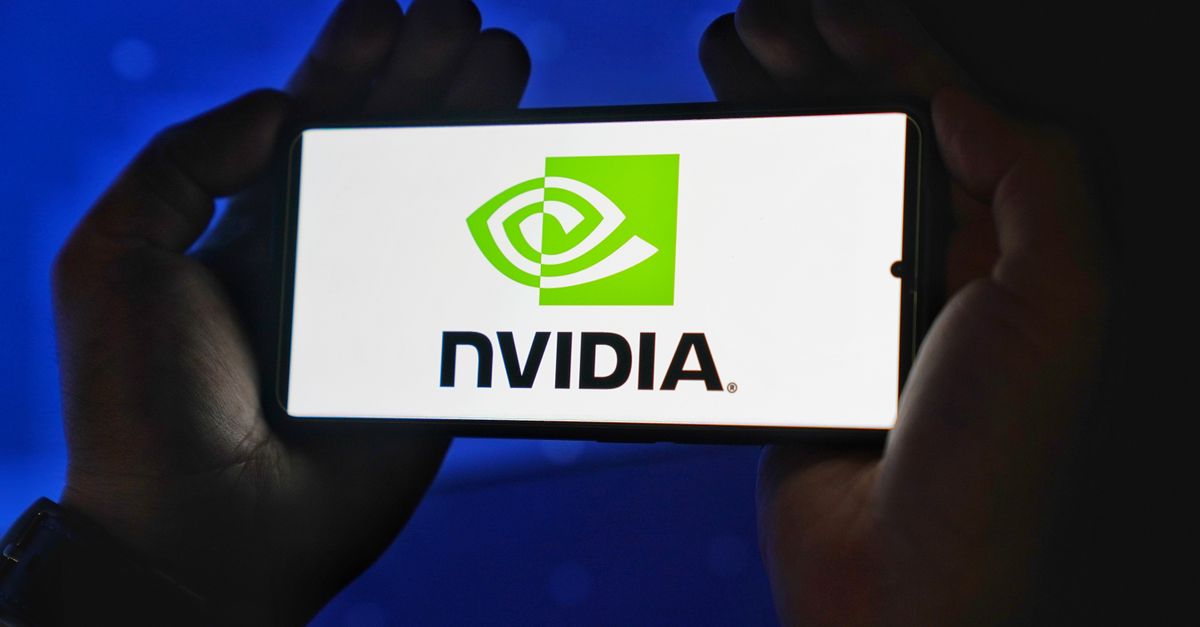Hands holding a smartphone showing the NVIDIA logo on a bright screen.