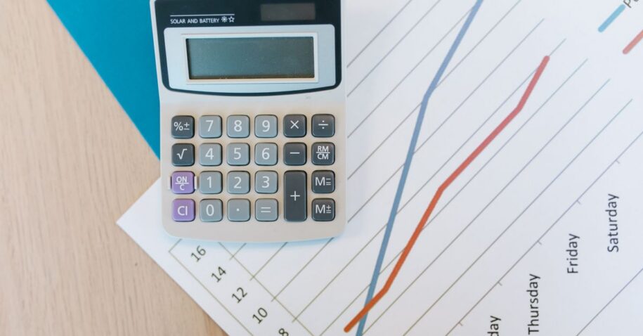 Top view of calculator and graph paper on office desk, perfect for business themed visuals.