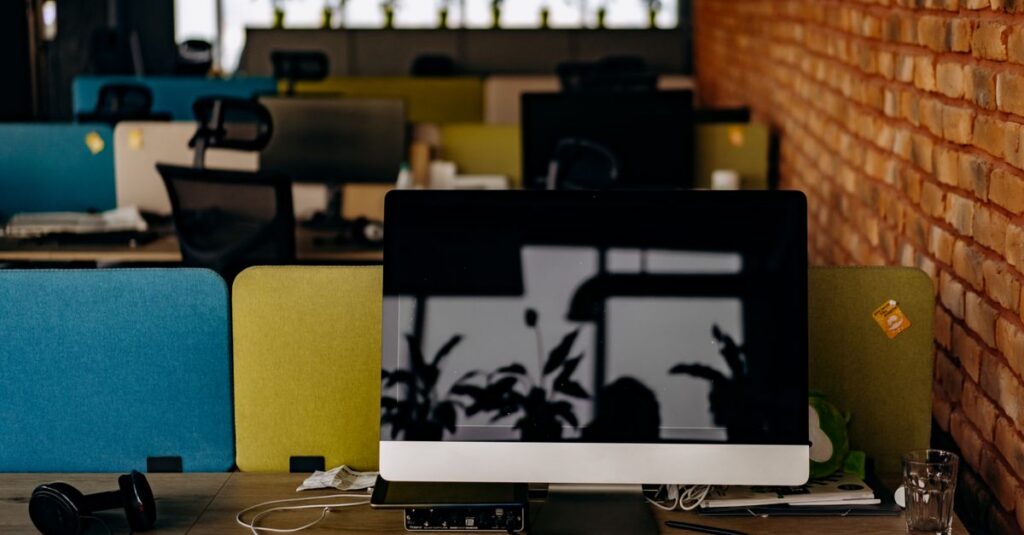 A clean, modern workspace with a computer on a desk in an empty office setting.